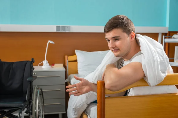 Male ill patient leaning on the hospital bedstead covered with q — Stock Photo, Image