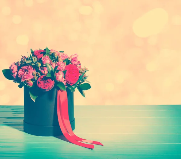 Hermoso ramo de rosas rosadas y rojas y cinta roja en un circo —  Fotos de Stock