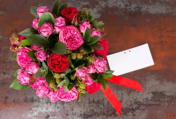 Güzel hediye etiketi ve kırmızı kurdele ile pembe gül buketi 