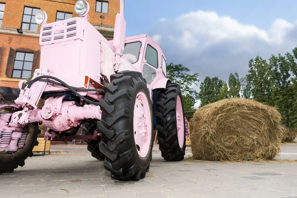 Вишуканий рожевий трактор біля стопи сіна — стокове фото