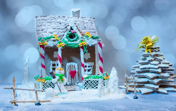 Casa de gengibre e árvore de Natal perto de um mastique de açúcar boneco de neve — Fotografia de Stock