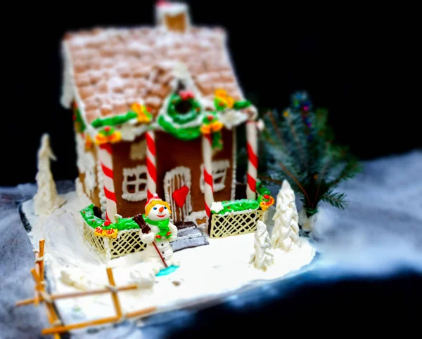 Big gingerbread house, a sprig of Christmas tree and a sugar mas — Stock Photo, Image