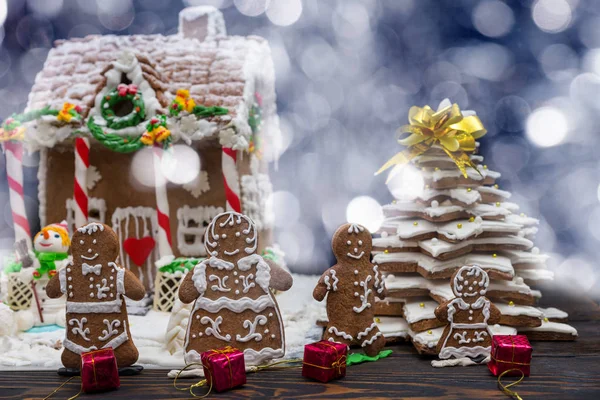 Cute gingerbread family with small red gifts near snow-covered h — Stock Photo, Image