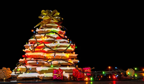 Big homemade gingerbread Christmas tree with lights on dark back — Stock Photo, Image