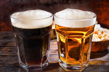 İle iki bardak taze koyu ve açık bira plaka w yakınındaki döktü