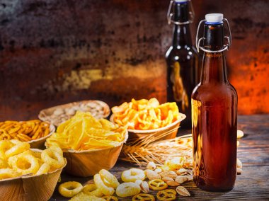 İki şişe bira, buğday, dağınık nu yakınındaki atıştırmalıklar ile plakalar