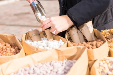 Tanınmayan eller fındık bir kağıt Kupası açık o dökün.