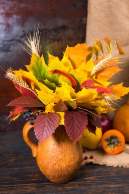 Elma hasat yanındaki güzel kil sürahisi ile sonbahar yaprakları 