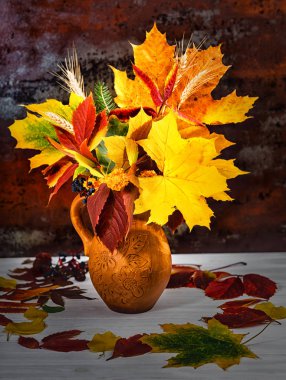 Sonbahar yaprakları ve buğday mavi ahşap d ile güzel kil sürahi