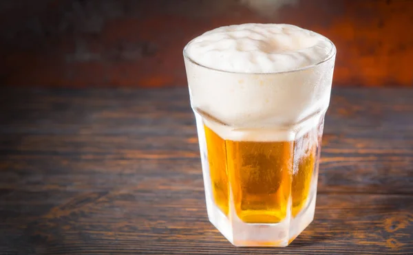 Μεγάλο παγωμένο ποτήρι, με μια ελαφριά μπίρα και ένα μεγάλο κεφάλι του αφρού στο o — Φωτογραφία Αρχείου