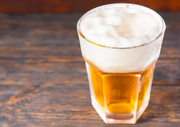 Κάτοψη του μεγάλο ποτήρι με μια ελαφριά μπίρα και ένα μεγάλο κεφάλι της αφρό — Φωτογραφία Αρχείου