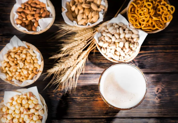 Draufsicht auf Glas mit frisch gegossenem Bier in der Nähe von Tellern mit Pist — Stockfoto