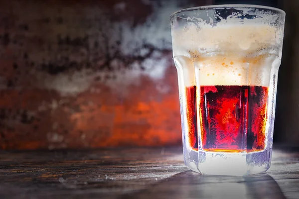 Большой замороженный стакан со свежим красным пивом и головкой пены — стоковое фото