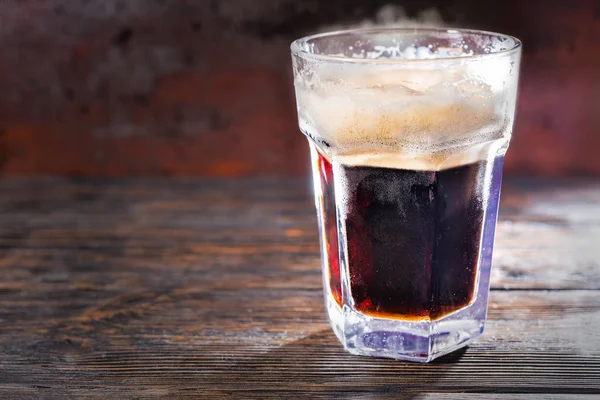 Big frozen glass with freshly poured dark beer and head of foam — Stock Photo, Image