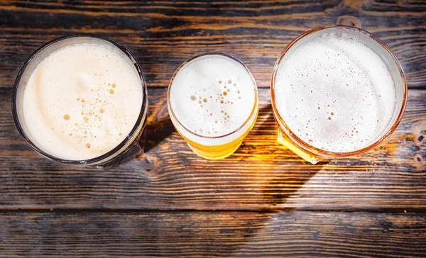 Top view of three glasses with light, unfiltered and dark beer o