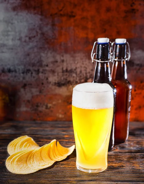 Big glass of freshly poured unfiltered light beer against two be — Stock Photo, Image