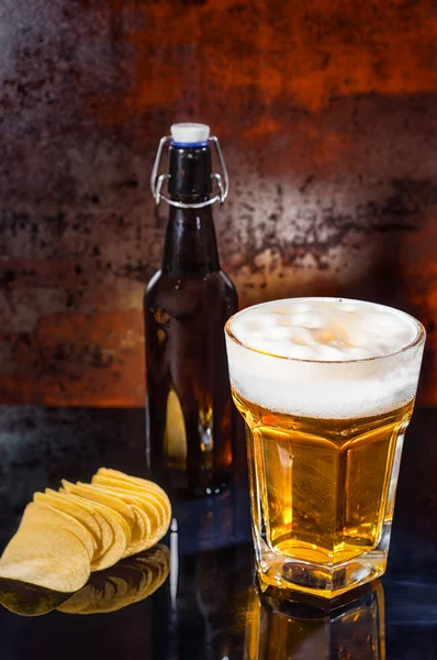 Glass with freshly poured light beer, beer bottle near scattered — Stock Photo, Image