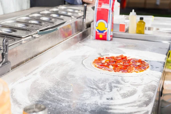 Pizza crua na superfície da cozinha com farinha — Fotografia de Stock