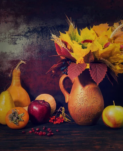 Prachtige clay kruik met herfst bladeren naast oogst van appels — Stockfoto