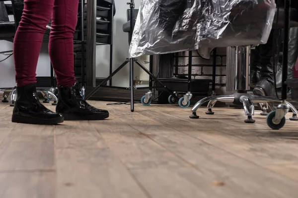 Füße einer Stylistin, die in der Nähe des Friseursessels arbeitet — Stockfoto