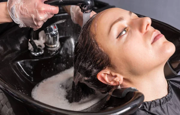 Vista de cerca del perfil de la mujer joven que tiene el pelo lavado por styli — Foto de Stock