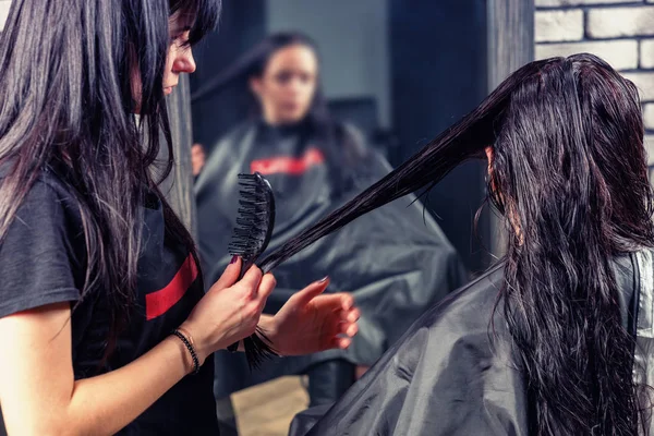 Close-up mãos de cabeleireiro profissional pentear o cabelo de jovens — Fotografia de Stock