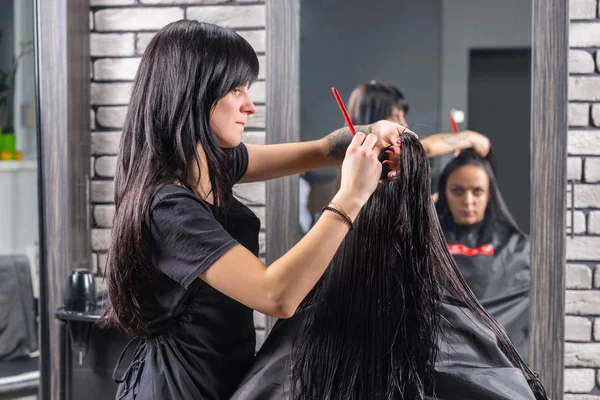 Donna attraente con lunghi capelli bagnati in attesa di taglio di capelli mentre pr — Foto Stock