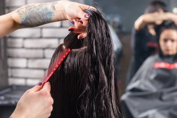 Fechar as mãos do cabeleireiro profissional pentear o cabelo molhado de br — Fotografia de Stock