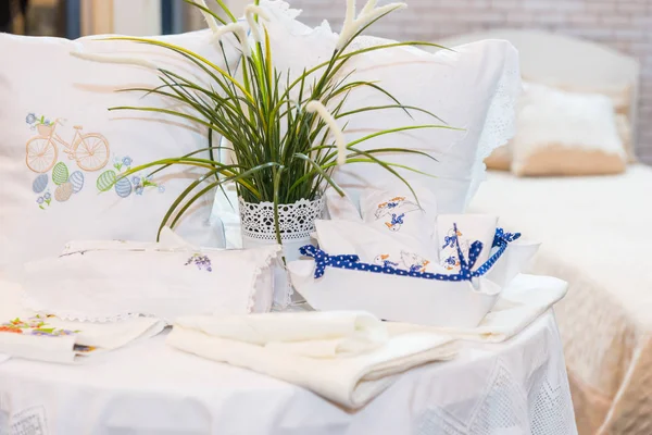 Conjunto de almohadas con bordado limpio cerca de ropa de cama y pla verde —  Fotos de Stock