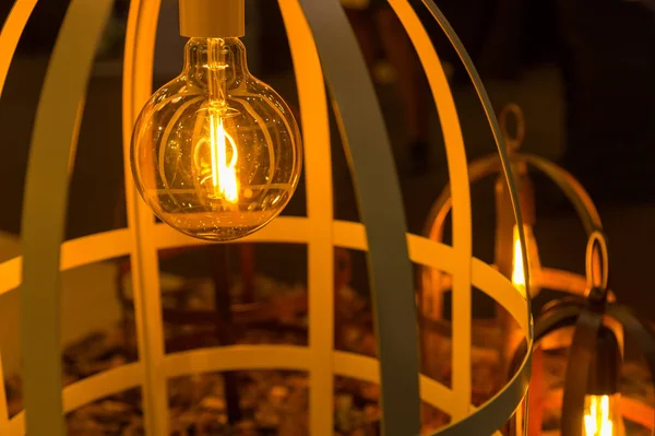 Close up of a lightbulb in home light in a wooden cage — Stock Photo, Image