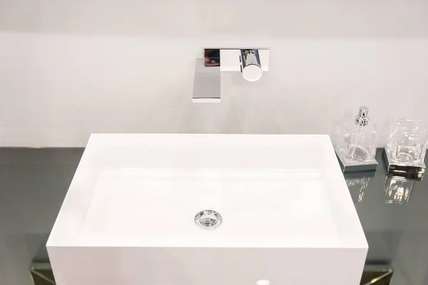 Lavabo cuadrado moderno cerca de recipientes de vidrio para jabón —  Fotos de Stock