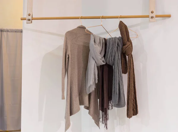 Moderne, gemütliche Garderobe mit Kleidern, die auf einem Holzbügel hängen — Stockfoto