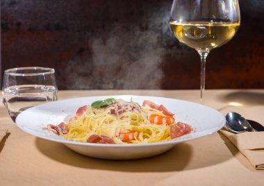 Cam şarap yakınındaki karides, spagetti makarna ile rendelenmiş peynir