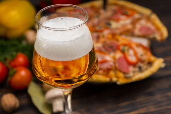 Glass of beer and appetizing pizza with salami on background — Stock Photo, Image