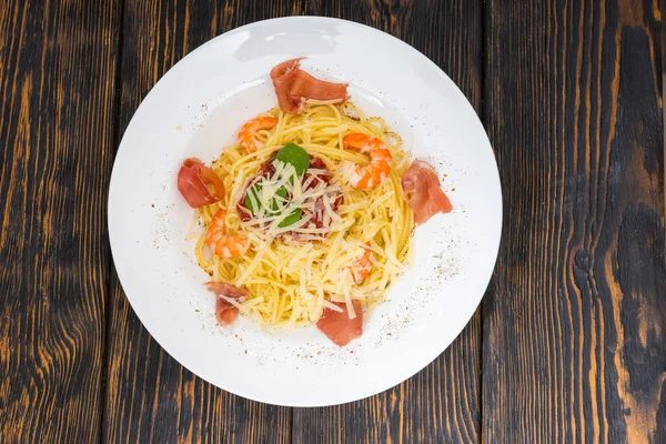 High angle view of tasty spaghetti pasta with shrimps, grated ch — Stock Photo, Image