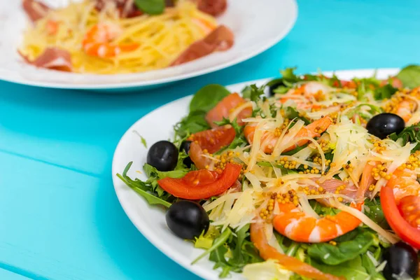 Close up de deliciosa salada em placa branca na mesa de madeira azul , — Fotografia de Stock