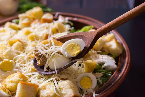 Grande prato de barro com salada de césar apetitosa com uma colher de madeira — Fotografia de Stock