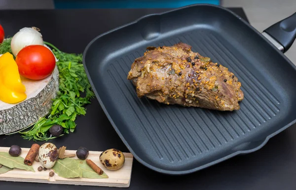Prepared marinated meat on a grill pan next to vegetables on a w — Stock Photo, Image