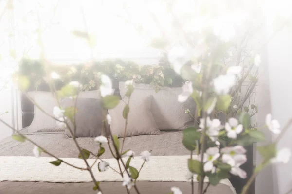 Fehér és szürke kényelmes hálószoba virág a ágykeret — Stock Fotó