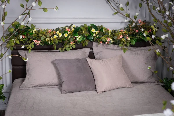 Gray cozy bedroom with flowers on the bedstead — Stock Photo, Image