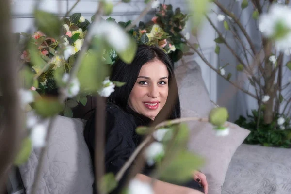 Kijk door middel van bloemen op de zwangere lachende brunette vrouw in b — Stockfoto