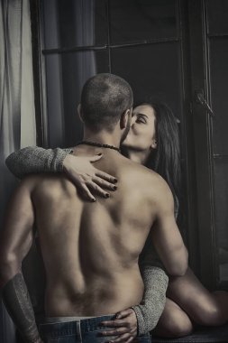 Örme giysili bir gönül esmer kadına windowsil üzerinde oturur