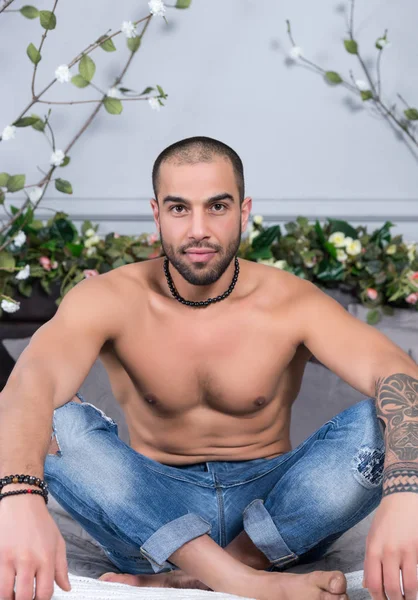 Bello uomo musulmano con petto nudo e con le mani tatuate seduto — Foto Stock