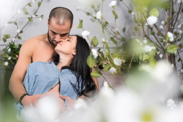 View from flowers on cute international couple of man with bare — Stock Photo, Image