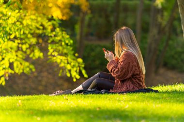 Cep telefonu kullanan genç bir kadın.