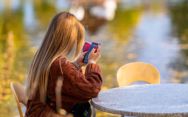 Молода жінка читає повідомлення мобільного телефону — стокове фото