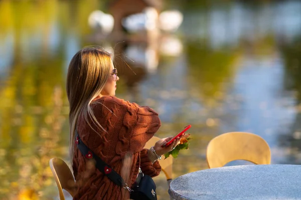 Junge Frau sitzt in einem Restaurant im Freien — Stockfoto