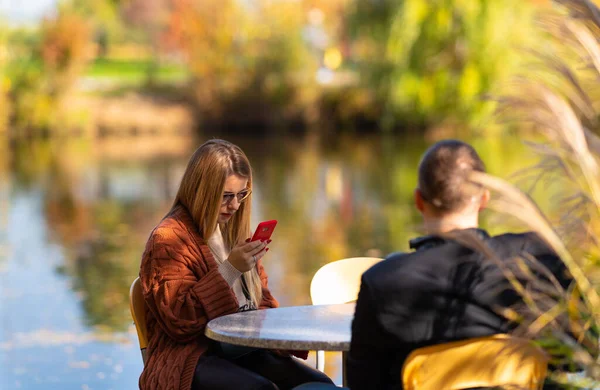 Genç bir kadın cep telefonunu kontrol ediyor. — Stok fotoğraf