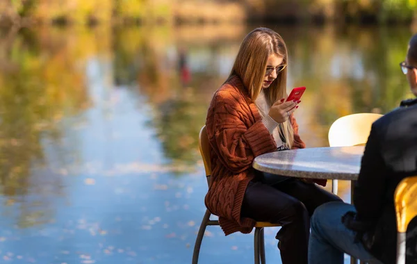 휴대폰으로 메시지를 읽고 있는 젊은 여자 — 스톡 사진