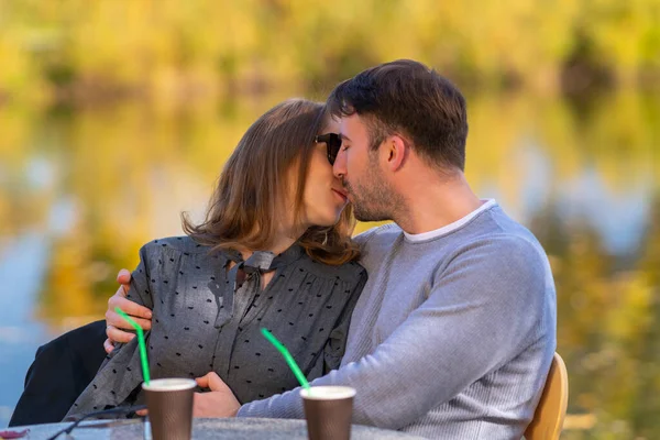 Kochająca młoda para całuje się w restauracji na świeżym powietrzu — Zdjęcie stockowe